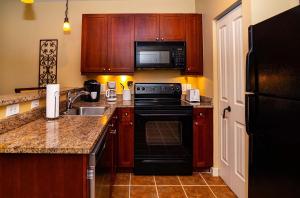 una cocina con armarios de madera y estufa negra en Private balcony-grand views-pool-hot tub 5326- S, en St. Augustine 24 fotos más