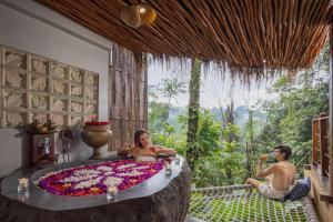 a woman sitting in a bathtub covered in flowers at Sacred Valley by GenuineHost in Tegalalang +76 photos