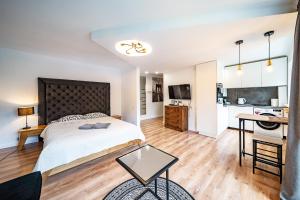 a bedroom with a large bed and a kitchen at Hugo apartment in Šiauliai