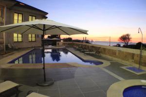 an umbrella sitting next to a swimming pool at Capricho de Bascuas in Bascuas