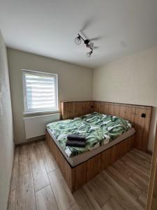un dormitorio con una cama y una ventana en Apartamenty DandE, en Władysławowo
