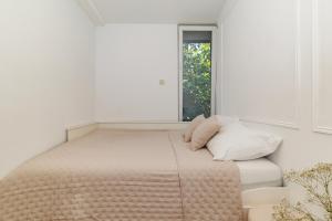 a bed in a white room with a window at Apartment Puntamica in Zadar