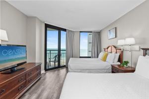 une chambre d'hôtel avec deux lits et une télévision à écran plat dans l'établissement WINTER RATES! Grand Oceanfront 1Br Suite, Dogs OK! 710, à Myrtle Beach