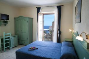 a bedroom with a blue bed and a window at Hotel San Francisco in Cala Gonone