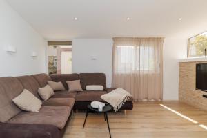 a living room with a brown couch and a television at Apartment Puntamica in Zadar