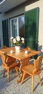 a wooden picnic table with chairs and a vase with flowers at Casa LUIS in Luino