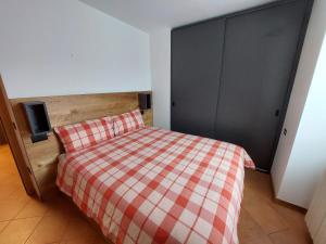 ein Schlafzimmer mit einem Bett mit einer karierten Decke in der Unterkunft Villa Emma in Ponte di Legno
