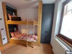 a wooden bunk bed in a room with a window at Villa Emma in Ponte di Legno