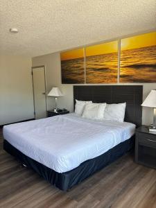 a large bed in a room with two lamps at Days Inn by Wyndham Caddo Valley Arkadelphia in Caddo Valley +16 photos