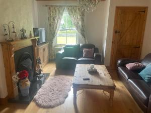 a living room with a couch and a coffee table at Katy Kellys Countryside Self Catering Cottage in Roscommon