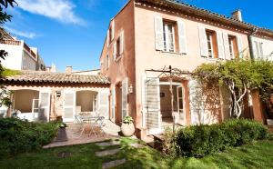 ein Haus mit einer Terrasse und einem Tisch im Hof in der Unterkunft Maison Jolie in Saint-Tropez