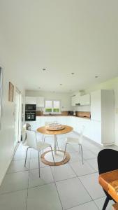a kitchen with a table and chairs in a room at Maison du Mont César in Montchaton
