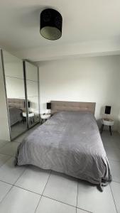 a bedroom with a large bed and two tables at Maison du Mont César in Montchaton