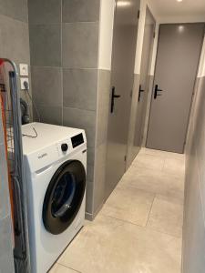 una lavanderia con lavatrice in camera di La maison de Julien a Bourbourg