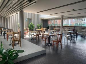 a restaurant with tables and chairs in a building at Hotel Holiday Inn Express & Suites Medellin by IHG in Medellín