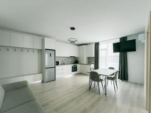 a living room and kitchen with a table and chairs at Corner Apartment in Bistriţa