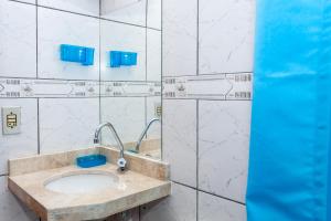 baño con lavabo en una pared de azulejos blancos en Casa Temporada Centro De Búzios, en Búzios