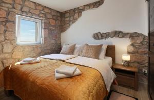 Un dormitorio con una cama grande con una pared de piedra. en Villa Ana, en Prizna 35 fotos más