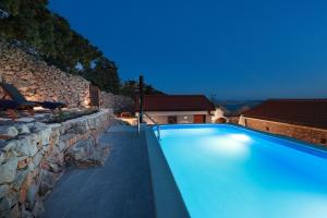 a swimming pool in front of a stone wall at Villa Ana in Prizna