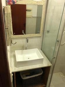 a bathroom with a white sink and a mirror at Refúgio Azul na Praia - Itaipuaçu-RJ in Maricá +31 photos