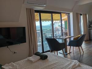 a bedroom with a bed and a view of a balcony at Apartments Provence in Sozopol