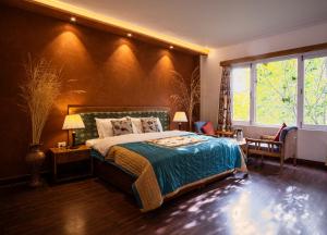 Un dormitorio con una cama y una ventana grande. en Hotel Lingzi - at the Mall Road & newly renovated, en Leh