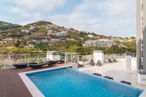 a pool on the roof of a house with a mountain at GuestReady - Calm Haven in Madeira in Caniço