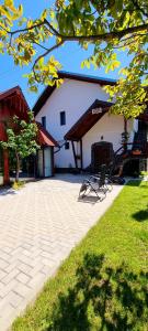 un patio con 2 sedie di fronte a un edificio di Casa FLOREA a Vama Buzăului