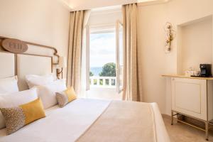 a bedroom with a bed and a large window at Grand Hotel Des Lecques; BW Signature Collection in Saint-Cyr-sur-Mer