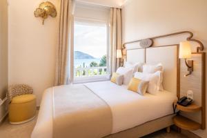 a bedroom with a large bed with a window at Grand Hotel Des Lecques; BW Signature Collection in Saint-Cyr-sur-Mer +88 photos