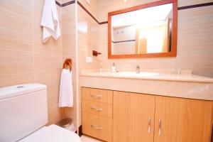 a bathroom with a sink and a mirror and a toilet at Expoholidays - Brisas de Almerimar in Almerimar +18 photos