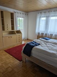 Un dormitorio con una cama, una cómoda y ventanas. en Ferienwohnung Gerstetten 85 qm - 2 Schlafzimmer - Küche mit großem Essbereich - Wohnzimmer - Balkon - Bad - ruhige Lage, en Gerstetten