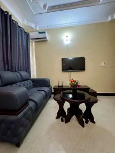 una sala de estar con un sofá y una mesa en Watra Apartments, en Dodoma