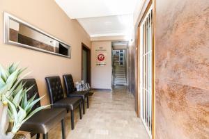 a corridor of a waiting room with leather chairs at La Locomotiva Rooms in Chiaravalle