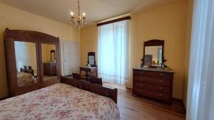 Un dormitorio con una cama, una cómoda y un espejo. en B&B Villa Margherita, en Lesa