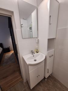 a white bathroom with a sink and a mirror at Ana's Garden Sibiu in Sibiu +12 photos
