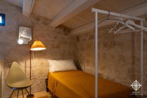 a bedroom with a bed and a lamp and a chair at Casa Aia - Rifugio Naturalistico in Frigintini