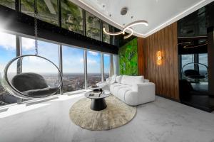 a living room with a white couch and a round mirror at In The Sky - Apartamenty w Sky Tower in Wrocław +229 photos