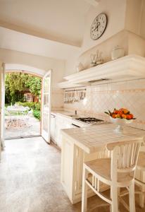 a kitchen with a table and a clock on the wall at Maison Jolie in Saint-Tropez +18 photos