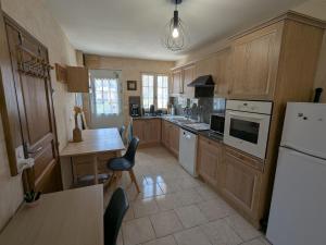 a kitchen with wooden cabinets and a white refrigerator at Appartement indépendant à Saran, proche Orléans - FR-1-590-574 in Saran