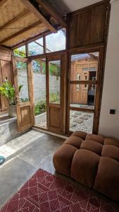a large brown couch in a room with windows at NEW The Loft - Uluwatu Surf Ranch in Uluwatu
