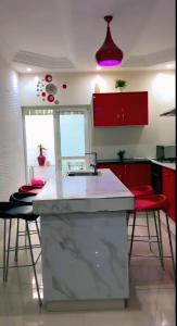 a kitchen with a white counter and red cabinets at LATOTALE Maison Rufisque 20mn AIBD in Rufisque +4 photos