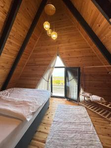 an attic bedroom with a bed and a window at Azhara Bungalow in Soğuksu