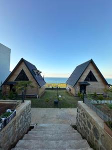 a couple of buildings with the ocean in the background at Azhara Bungalow in Soğuksu