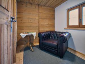 a leather chair in a room with a table at Haus ANTONIUS - AlpenLuxus Collection in Reith im Alpbachtal