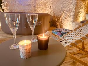 a table with two wine glasses and candles on it at "Ninho de Amor" troglodyte unique in Montrichard +30 photos