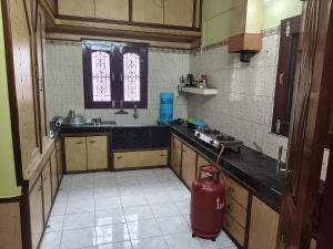 a kitchen with a stove and a sink and a window at Comfort home stay in Sivasagar