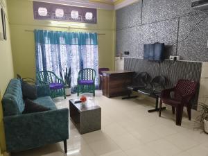 a living room with a couch and chairs and a tv at Comfort home stay in Sivasagar