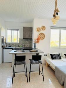 a kitchen and living room with a table and chairs at Giorgos concept suites AGAPI in Edipsos