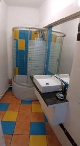 un bagno con lavandino, WC e specchio di Domum Unirea, across the street of Old City Center a Bucarest Altre 42 foto